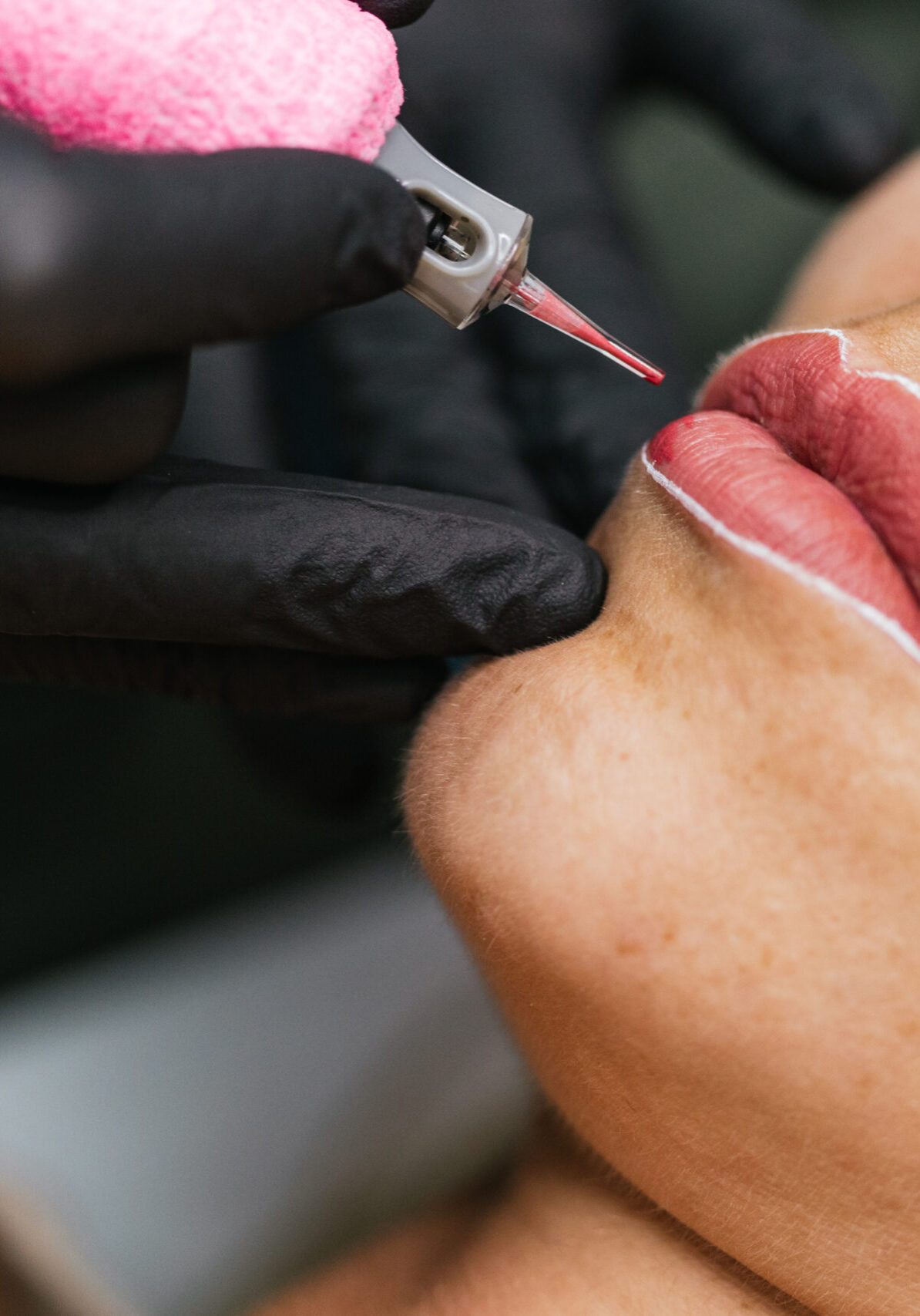 Closeup of cosmetologist performing micropigmentation on client's lips, enhancing color and shape with precision and care in a beauty salon