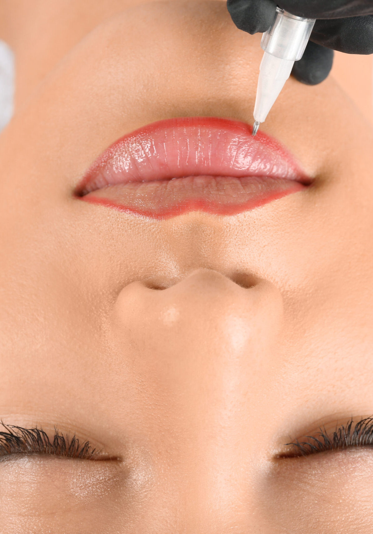 Young woman getting permanent makeup on lips in beautician salon, closeup